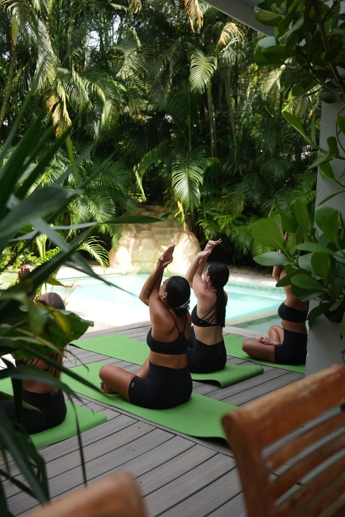 Yoga session by the pool surrounded by jungle